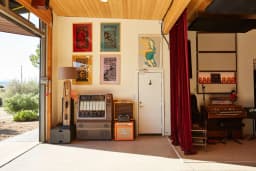 Studio One at ESCAPE Studios with guitars and equipment near the open desert-facing doorway