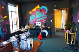 Rock Room with guitars, drums, and colorful wall art at Paradise Recording