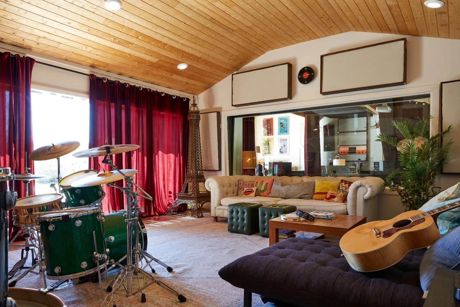 Main recording room with drums, guitar, and lounge seating at ESCAPE Studios